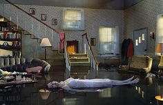 a woman laying on the floor in a living room next to a man with his head down