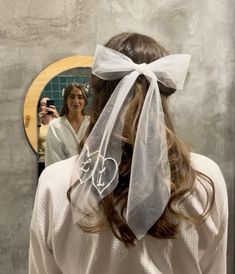 a woman with a veil on her head in front of a mirror