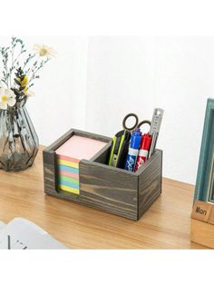 a desk with a pen, pencils, scissors and other office supplies on it