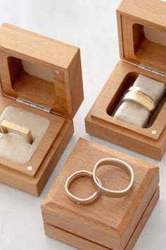 three wooden boxes with wedding rings in them