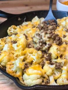 a cast iron skillet filled with cheese and ground beef covered in melted cheddar