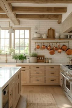 a kitchen filled with lots of wooden cabinets and counter top covered in pots and pans