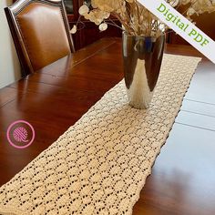 a table runner with crocheted doily on it and flowers in a vase