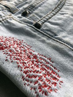 a pair of jeans with red stitching on them