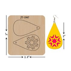 a pair of yellow and red earrings next to a wooden plaque with an image of a star on it