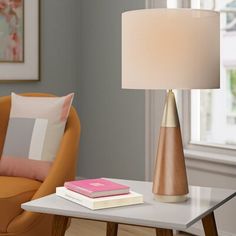 Doubling as a modern accent piece and a source of light, this 26" table lamp makes a statement as it boosts the brightness in your space. Defined by its distinctive mix of materials, its cone-shaped base is crafted from solid rubberwood in a brown finish with antique brass-finished metal places for mid-century inspiration. Above, an understated linen drum shade rounds out the look with contemporary appeal, diffusing light from a compatible 60 W bulb in an ambient direction. Corrigan Studio® | Co Modern Side Table Lamp, Architectural Table, Triangular Table, Mid Century Modern Side Table, Mid Century Modern Table Lamps, Mid Century Table Lamp, Fixture Table, Side Table Lamps, Mid Century Lighting