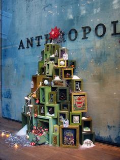 a christmas tree made out of boxes and other items in front of an antholopol sign