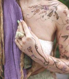 a woman with tattoos on her arm holding a purple scarf