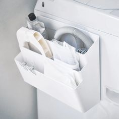 a white toilet sitting next to a washer and dryer in a bathroom with the lid open