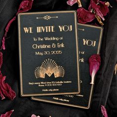 two black and gold wedding cards with rose petals