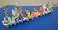 an egg carton filled with different types of animals on top of a blue table