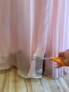 someone is cutting through the curtain with scissors