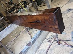 an unfinished piece of wood sitting on top of a wooden table in a room filled with tools