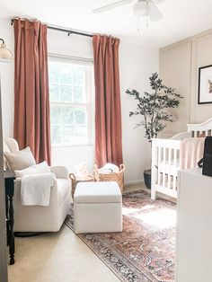 a baby's room with a crib, chair, and ottoman in it