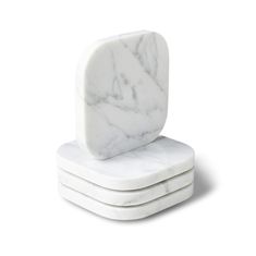 three white marble coasters stacked on top of each other, one with a square shape