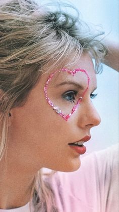 a woman with her face painted like a heart and the word love spelled in pink