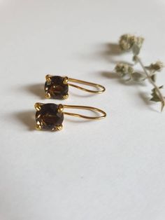 Smokey quartz earrings, gold delicate earrings, gold vintage earrings, classic earrings, birthstone earrings, brown gemstone earrings, gift for her These vintage inspired earrings were delicately handmade and are minimalist and classic. They are made of 14k gold filled and 14k gold plated brass. Dimensions: Gemstone size is 7X7 mm, with a facet finish Total drop is 0.75 inches. Can be ordered in sterling silver or other gemstones. Just let me know what you like and I will do my best to accommoda Elegant Brown Earrings For Anniversary, Classic Brown Jewelry With Matching Earrings, Vintage Brown Earrings For Everyday, Elegant Brown Brass Earrings, Brown Natural Stone Drop Earrings, Brown Gemstone Drop Earrings, 14k Gold-filled Gemstone Drop Earrings, Silver 14k Gold-filled Gemstone Earrings, Green Amethyst Earrings