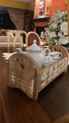 a wooden table topped with a white vase filled with flowers