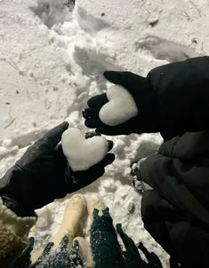 two people are standing in the snow with gloves on and one person is holding out their hands