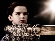 a young boy holding a large metal object in his hands