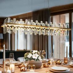 a dining room table is set with candles, plates and glasses for dinner guests to enjoy