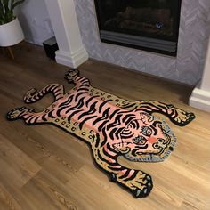 a tiger rug is laying on the floor in front of a fireplace