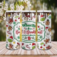 two christmas themed tumblers sitting on top of a wooden table