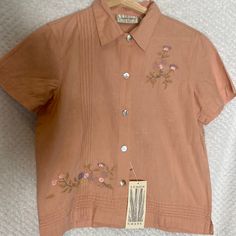 Lemon Grass Blouse Top Peach Color With Flowers Embroidery Womens Ladies Petite Small Ps New With Tags Nwt Summer Embroidered Collared Tops, Summer Collared Tops With Floral Embroidery, Spring Short Sleeve Blouse With Tonal Embroidery, Spring Tops With Tonal Embroidery And Short Sleeves, Pink Embroidered Button-up Blouse, Short Sleeve Tops With Tonal Embroidery For Spring, Summer Embroidered Collared Blouse, Summer Collared Blouse With Embroidery, Spring Collared Top With Floral Embroidery