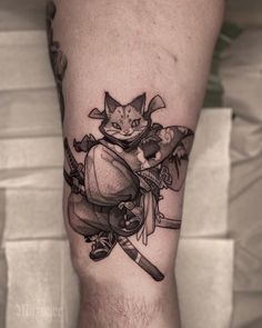 a tattoo on the leg of a man with a cat and knife in his hand