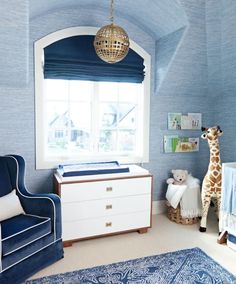 a baby's room with blue and white decor, including a giraffe