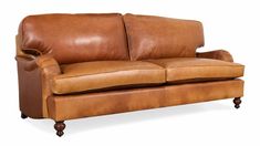 a brown leather couch sitting on top of a wooden frame