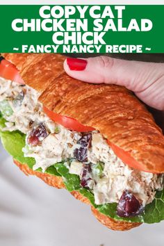 a chicken salad sandwich with lettuce, tomatoes and cranberries on it