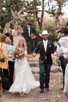 a bride and groom walk down the aisle as confetti is thrown around them