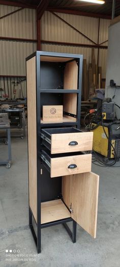 an open cabinet with two drawers in a garage area next to other workbenches