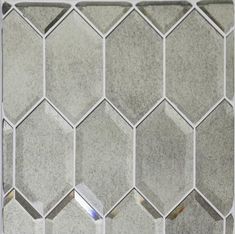 a close up view of a tile wall with hexagonal tiles in grey and white