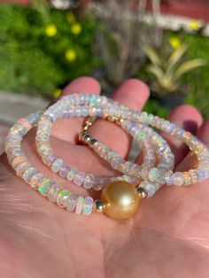 "Large (4.5-5mm) and beautiful faceted Ethiopian opal rondelles frame a flawless 11mm deep golden South Sea pearl.  The snow-white opals make a lovely contrast to the pearl, with their subtle multi-colored fire, and the South Sea pearl is a rich shade of gold. Necklace measures 16\" - 19\" in length and can be worn as a choker and layered with other pieces; it comes accented with 14K yellow gold-filled beads around the pearl and at the lobster clasp, with an additional 3\" gold-filled extender chain at the clasp.  If you prefer a different length, please convo me or let me know in the check-out comments. Thanks for checking out my shop!" Gold Opal Round Beads Necklace, Gold Opal Necklace With Round Beads, Gold Opal Single Strand Jewelry, Gold Opal Jewelry With Round Beads, Pearl Rondelle Jewelry With Faceted Beads, Rondelle Pearl Jewelry With Faceted Beads, Pink Opal Round Beads Jewelry, Faceted Round Opal Jewelry, Round Faceted Opal Jewelry