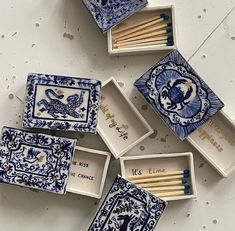 blue and white matchboxes with matches in them sitting on the floor next to each other