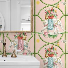 a bathroom with pink and green wallpaper has an elephant design on the wall next to a white sink