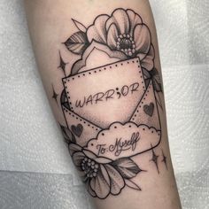 a black and white photo of a woman's arm with a tattoo on it