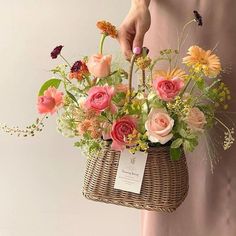 a person holding a basket with flowers in it and a price tag on the handle