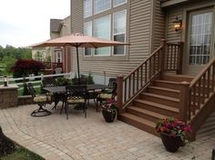 a patio with chairs, table and umbrella