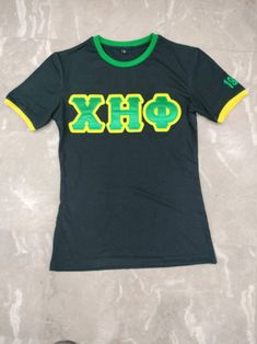 Satin Backed twill Greek letters embroidered onto black cotton with green neckline and founding year embroidered onto yellow ringer sleeves. This t-shirt would pair well with your casual para and accentuate your style!   UNISEX SIZING. if you are unsure of the fit, please message us for recommendations based on your body type and normal size. we would be happy to make this a great buyer experience.  Stand out while providing service for humanity and pair with your finest yellow and green scrub bottoms, jeans, and hats for the spring. 🐢 💛💚 🐢 Sizes S-4XL (Larger sizes in limited quantities)  🐢 Shipped in box if combined with hat. otherwise will be shipped in envelope with care towards the Greek lettering.    🐢 Washing Instructions: -  Machine wash in cold water. -  Dry clean Green Embroidered Text Short Sleeve T-shirt, Black Cotton T-shirt With Letter Embroidery, Black Letter Embroidery T-shirt For Streetwear, Casual Green T-shirt With Embroidered Logo, Green Cotton Tops With Embroidered Logo, Green Cotton Top With Embroidered Logo, Embroidered Green Tops For Streetwear, Collegiate Green Letter Print T-shirt, Green Collegiate T-shirt With Letter Print