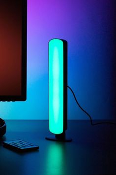 a computer monitor and keyboard on a desk in front of a neon colored wallpaper