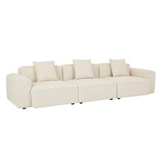 a white couch with four pillows on the back and one arm folded out to form a reclining sofa