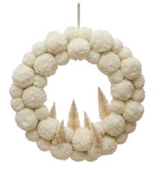 a wreath with white pom - poms hanging from it's center and four spikes on the front