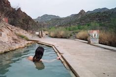 a woman is in the water with her back turned to the camera