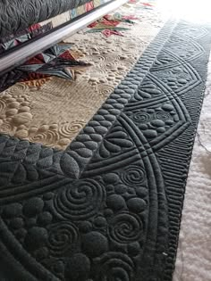 a close up view of a quilt on the floor with it's edge stitched together