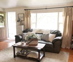 a living room filled with furniture and a wooden coffee table in front of a window