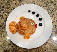 a white plate topped with pancakes covered in fruit