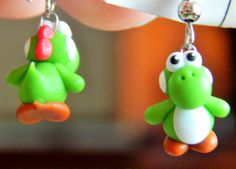 a pair of green and white toy animals hanging from earrings